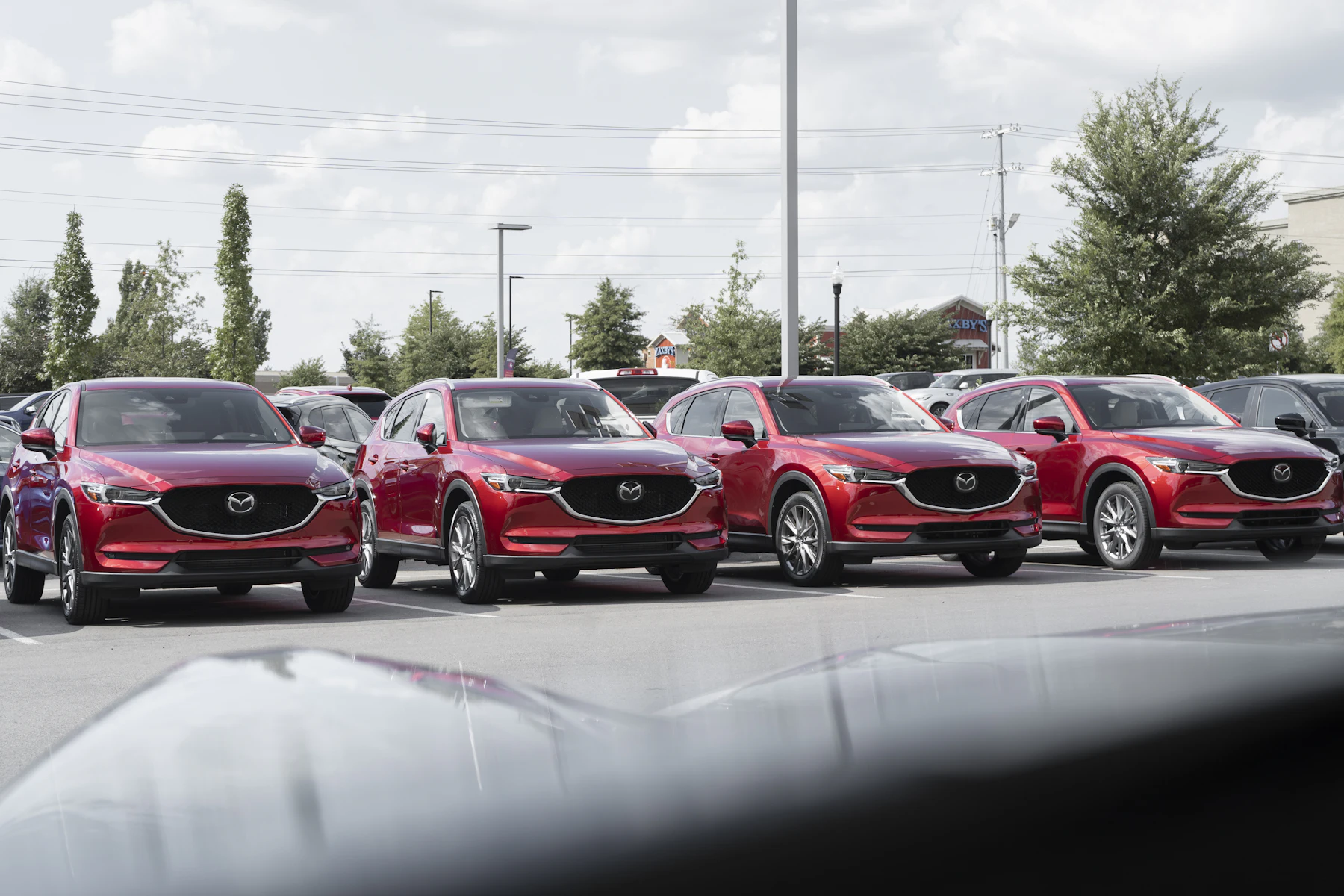 A row of cars for sale on a dealership lot